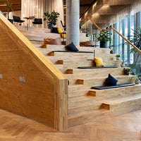 Großzügige Holztreppe mit integrierten Sitzflächen und Eichenparkett in einem modernen Innenraum.
