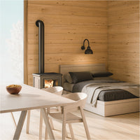 Wohnraum mit hellen Holzmöbeln, Holzwänden und Kaminofen als Inspiration für natürliche Holzgestaltung im Innenbereich