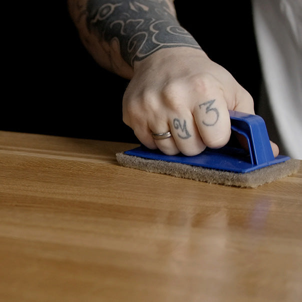 OLI NATURA HS Profiöl NATUR wird mit einem Handpad in eine Holzoberfläche eingearbeitet.