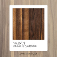 Nussbaum mit OLI NATURA® HS Profiöl NATUR geölt, mit kräftiger Farbvertiefung und betonter Maserung – unbehandelter Nussbaum im Hintergrund