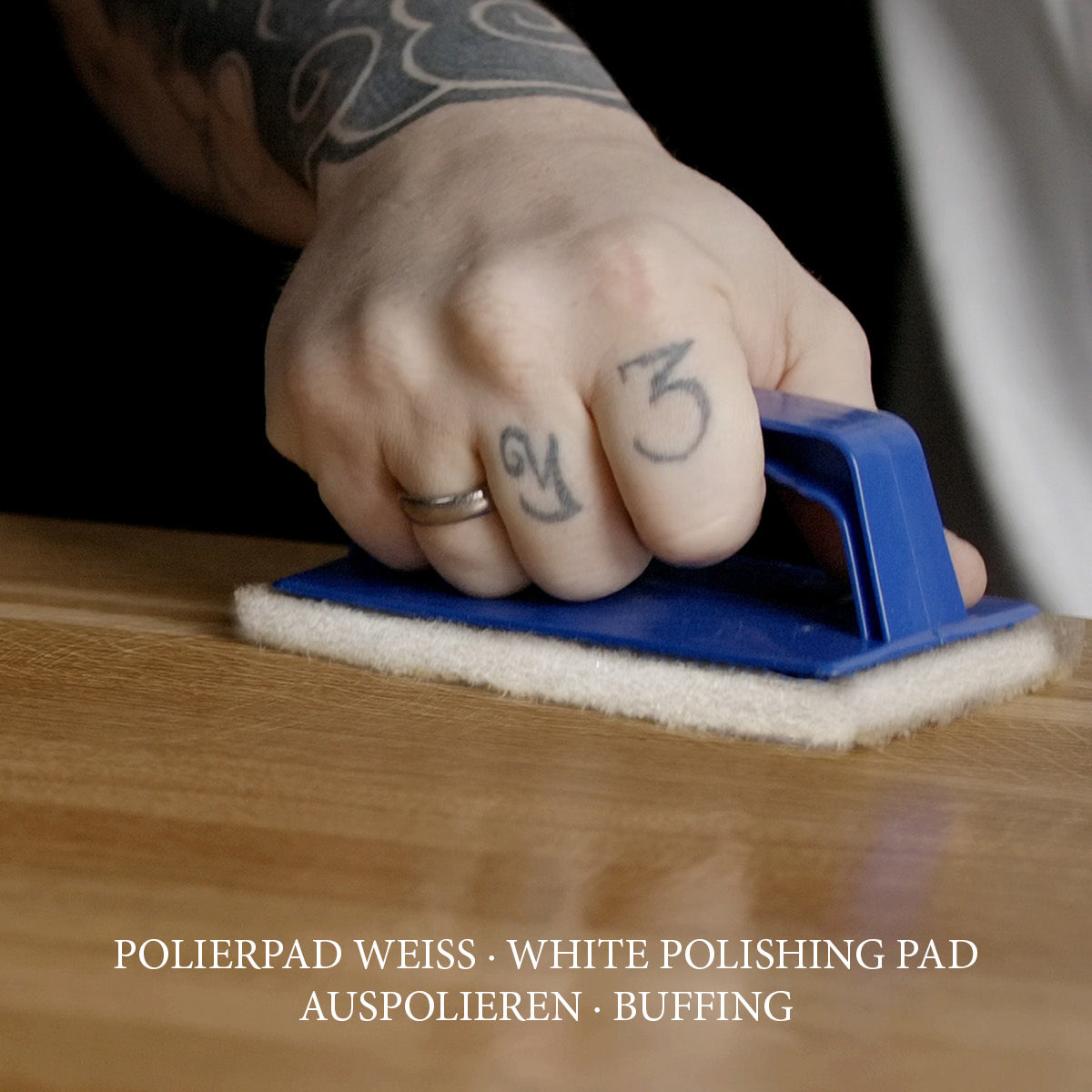 Weißes Polierpad mit Hand-Padhalter zum abschließenden Auspolieren einer frisch geölten Holzoberfläche.
