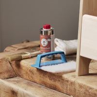 Anwendung von OLI NATURA® Hartwachsöl auf Holz: dünn auftragen, einwirken lassen, überschüssiges Öl abnehmen und mit einem weißen Pad auspolieren.